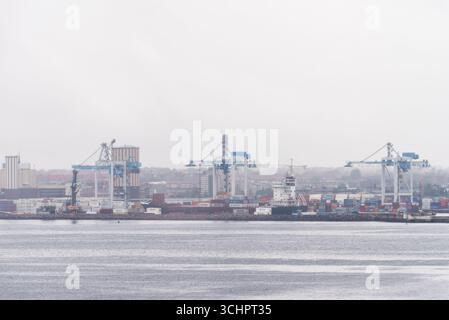 Containerhafen mit Kranen Helsingborg Schweden / HELSINGBORG, Schweden — Containerkrane fahren im Hafen Helsingborg, einem bedeutenden Seeknotenpunkt in Südschweden, unter nebeligen Bedingungen. Der Hafen erleichtert den Warenverkehr und ist ein wichtiger Bestandteil der Infrastruktur der Region. Helsingborg liegt im schwedischen Komitat Skåne. Stockfoto
