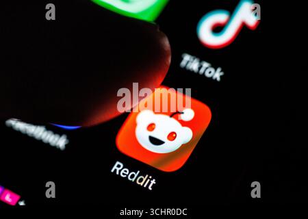 Norden, Deutschland. September 2025. Das Logo der Reddit App ist am 2. September 2025 auf dem Display eines Smartphones zu sehen, während sich ein Zeigefinger dem Symbol der Anwendung nähert. Reddit ist eine soziale Nachrichtenplattform und ein Forum, das aus themenspezifischen Communities besteht, die als „Subreddits“ bekannt sind. Nutzer können Links, Texte, Bilder und Videos posten und in den jeweiligen Unterreddits diskutieren. (Soziales Netzwerk, soziale Medien, Symbolbild, Symbolfoto, Illustration, symbolisches Foto, illustratives Foto, Themenbild, allgemeines Bild, Themenfoto) Credit: Matthias Balk/dpa/Alamy Live News Stockfoto