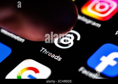 Norden, Deutschland. September 2025. Das Logo der Threads App ist am 2. September 2025 auf dem Display eines Smartphones zu sehen, während sich ein Zeigefinger dem Symbol der Anwendung nähert. Threads ist eine textbasierte Social-Media-Plattform von Meta (dem Unternehmen hinter Instagram), mit der Benutzer öffentliche Gespräche führen und Beiträge in Form von „Threads“ erstellen können (soziales Netzwerk, soziale Medien, Icon-Bild, Icon-Foto, Illustration, ikonisches Foto, illustratives Foto, Themenbild, allgemeines Bild, Themenfoto) Credit: Matthias Balk/dpa/Alamy Live News Stockfoto