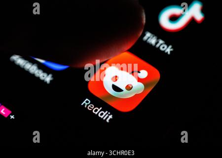 Norden, Deutschland. September 2025. Das Logo der Reddit App ist am 2. September 2025 auf dem Display eines Smartphones zu sehen, während sich ein Zeigefinger dem Symbol der Anwendung nähert. Reddit ist eine soziale Nachrichtenplattform und ein Forum, das aus themenspezifischen Communities besteht, die als „Subreddits“ bekannt sind. Nutzer können Links, Texte, Bilder und Videos posten und in den jeweiligen Unterreddits diskutieren. (Soziales Netzwerk, soziale Medien, Symbolbild, Symbolfoto, Illustration, symbolisches Foto, illustratives Foto, Themenbild, allgemeines Bild, Themenfoto) Credit: Matthias Balk/dpa/Alamy Live News Stockfoto