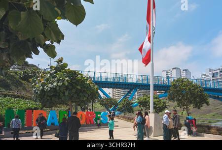 Lima peru aug 30 2025: Die peruanische Flagge winkt in der Nähe der neuen zweihundertjährigen Brücke im Stadtteil miraflores von lima, wo Touristen spazieren gehen und die Stadt genießen Stockfoto