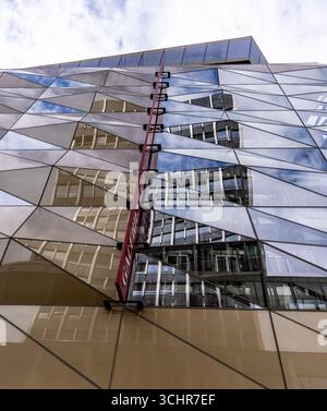 LUXEMBURG, EUROPA - 1. SEPTEMBER 2025 - die geometrische Glasfassade der Galeries Lafayette spiegelt die Stadtlandschaft und den bewölkten Himmel in Luxemburg-Stadt wider Stockfoto