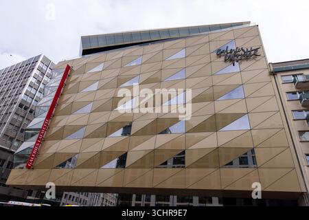 LUXEMBURG, EUROPA - 1. SEPTEMBER 2025 - Geometrische Fassade eines Kaufhausgebäudes mit dreieckigen Glaspaneelen, die das Stadtbild von Lux widerspiegeln Stockfoto