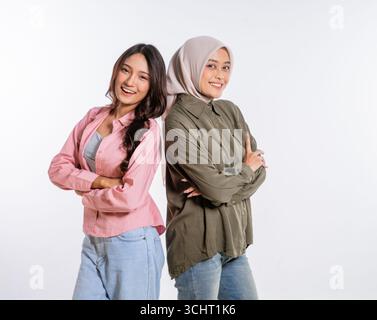 Zwei verschiedene Frauen lächeln glücklich zusammen in einem Studio-Porträt Stockfoto