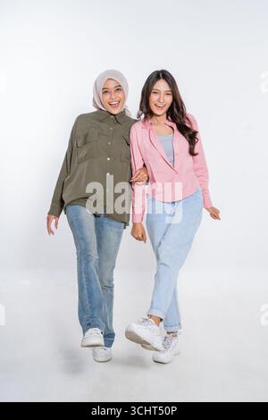 Fröhliche, modische Freunde, die sich in lässigen Outfits in einem Studio ausgeben Stockfoto