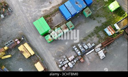 Industrieller Lagerplatz von oben – Luftaufnahme von Containern, Anlagen und Baumaterialien Stockfoto