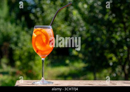 Aperol spritzt Cocktail in Weinglas auf einem Naturhintergrund. Klassischer italienischer Aperitif aperol Spritz-Cocktail mit Orangen- und Eiswürfeln. Nahaufnahme, Kopieren Stockfoto