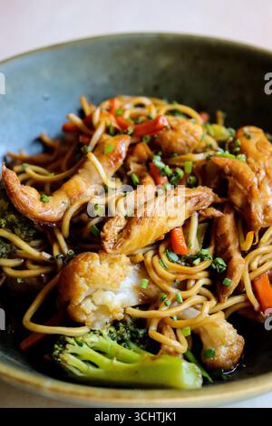Nahaufnahme von einem Teller Hühnerchow mein. Zarte Hühnerstreifen, buntes, knuspriges Gemüse wie hellgrüner Brokkoli, rot Stockfoto