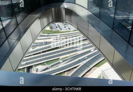 Blick auf den komplizierten Autobahnkreuz von einem Glasboden aus dem modernen Dubai-Gebäude mit Autos, die auf den mehrstöckigen Straßen unter der Aussichtsplattform fahren Stockfoto