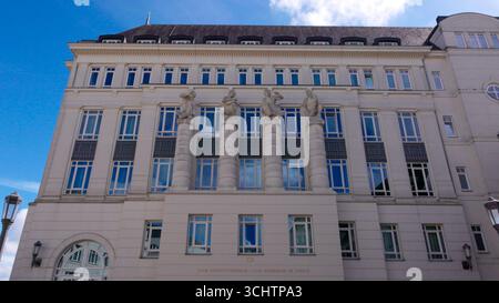 LUXEMBURG, EUROPA - 1. SEPTEMBER 2025 - Niedrigwinkelblick auf das Gebäude des Handelsgerichts in Luxemburg-Stadt mit Statuen und blauem Himmel Stockfoto
