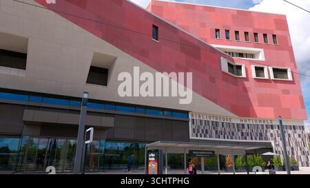 LUXEMBURG, EUROPA - 1. SEPTEMBER 2025 - Moderne Architektur der Nationalbibliothek in Luxemburg-Stadt mit roter und grauer Fassade und Straßenbahnkabeln Stockfoto