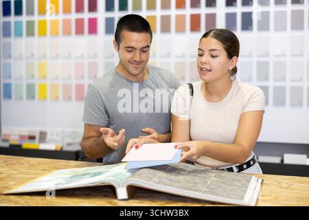 Ein Ehepaar wählt die Farbe der Keramikfliesen aus dem Katalog im Baumarkt Stockfoto