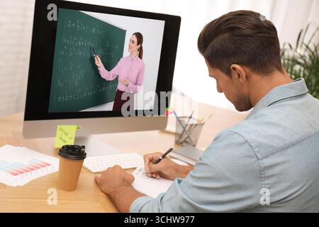 E-Learning-Konzept. Schüler, der Online-Videochat mit dem Lehrer über einen Computer am Schreibtisch führt Stockfoto