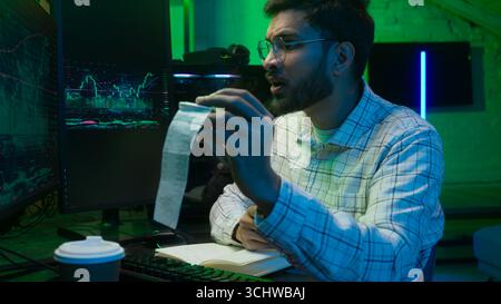 Arabian Indian man männlicher Programmierer untersucht das Schreiben von Binärcode Coder freiberuflicher Ingenieur Arbeiter IT Spezialist Monitor Analyse Computer Stockfoto