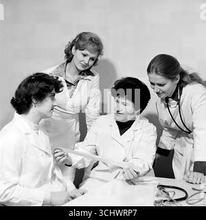 Ein archiviertes Schwarzweißfoto, aufgenommen in einem Krankenhaus im Mashmet-Bezirk von Sloviansk in den 1970er Jahren Eine Gruppe von Ärzten oder Krankenschwestern in weißen Mänteln untersucht gemeinsam einen Röntgenfilm. Die Rahmen spiegeln die tägliche Arbeit, Professionalität und den kollektiven Ansatz in der sowjetischen Medizin wider. Das Foto ist ein Symbol für die friedliche Arbeit der Ärzte in Sloviansk Stockfoto