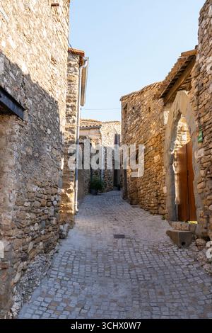 Enge Gassen von Minerve, Occitanie, Frankreich, mit mittelalterlichen Steinbauten in hellen Beige- und Brauntönen Stockfoto