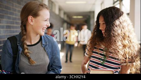 Lachen, gehen und Freunde auf der Highschool im Flur, um gemeinsam zu lernen, zu lernen und zu lernen. Glücklich, Campus und Teenager im Gespräch, reden Stockfoto