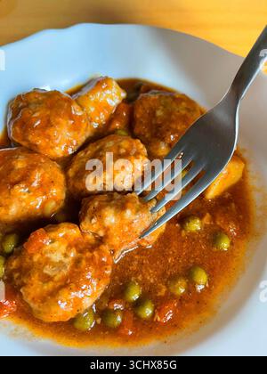 Fleischbällchen mit Gemüsesauce essen. Spanien. Stockfoto