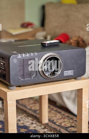 BARNAUL, SIBIRIEN, REGION ALTAI, RUSSLAND - 6. Mai 2020: Panasonic-Projektor mit schwarzem Heimkino auf Holztisch im Wohnzimmer mit Fernbedienung in der Nähe. Stockfoto