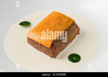 Gourmet-Rindfleisch mit cremiger weißer Sauce und knusprigem Topping Stockfoto
