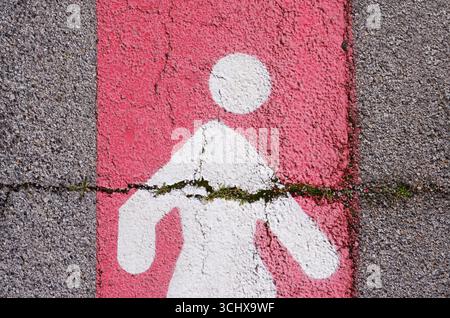 Ein kaputtes Fußgängersymbol auf der Straße Stockfoto