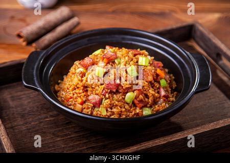 Gebratener Reis im amerikanischen Stil in einem Topf aus schwarzem Ton Stockfoto