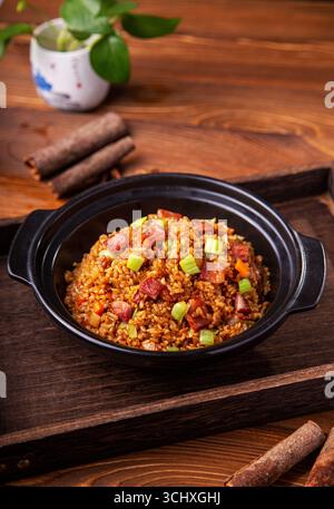 Amerikanischer Speck gebratener Reis im Tontopf auf Holztablett Stockfoto