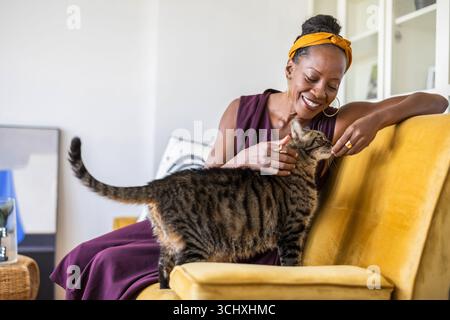 Porträt einer lächelnden Frau mit ihrer Katze zu Hause Stockfoto