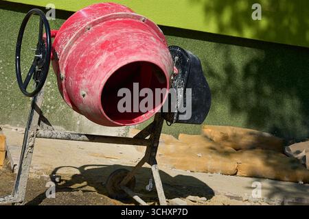 Tragbarer Zement. Bau elektrischer Mini-Betonmischer auf Sand Stockfoto