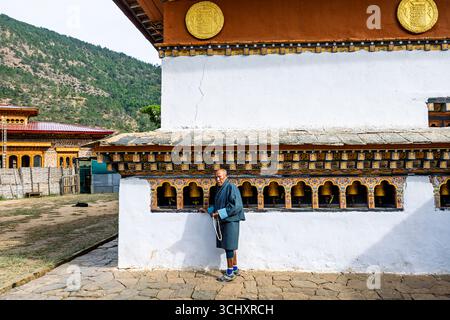 Ein Gläubiger spinnt Gebetswender in Chimi Lhakhang, dem Mad Mönch Tempel, Teoprongchu Dorf bei Sopsokha, Lobesa Tal, Punakha District, Bhutan Stockfoto