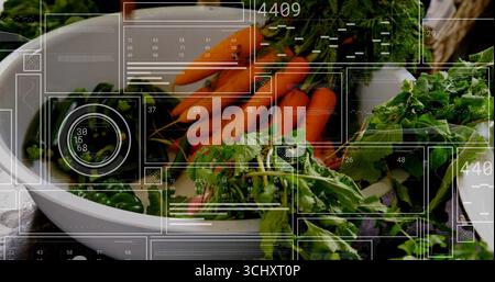 Weiße Schüssel mit leuchtend orangefarbenen Karotten auf hölzernem Arbeitsplatte, mit digitalen Tafeln Stockfoto