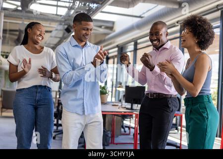 Geschäftsteams klatschen und lächeln in modernen Büros und feiern gemeinsam Erfolge Stockfoto