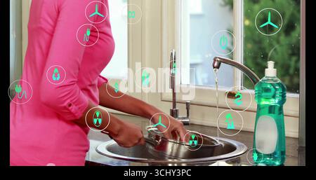 Frau mit rosafarbenem Spültopf unter dem Wasserhahn in der Küchenspüle, mit Seife, Öko-Ikonen, Kopierraum Stockfoto