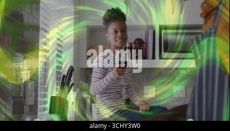 Sitzende Frau mit gestreiftem Hemd, die Weinglas auf der Küchenarbeitsplatte hält, mit Messerblock Stockfoto