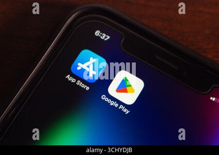 Smartphone-Bildschirm mit nebeneinander stehenden Symbolen für Google Play und App Store, die Android- und iOS-App-Plattformen darstellen. Stockfoto