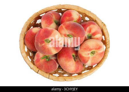 chinesische flache Donut-Pfirsiche in einem Korb isoliert auf weißem Hintergrund. Draufsicht. Flache Lagen Stockfoto