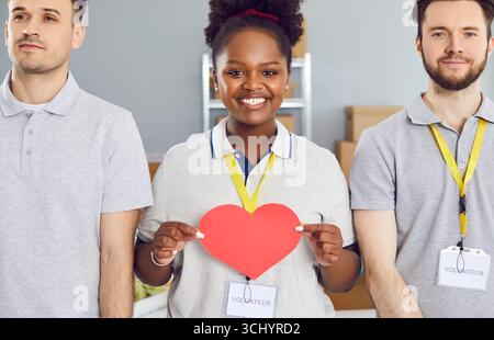 afroamerikanerin, die freiwillig Red Heart hält, ist in einer gemeinnützigen Stiftung tätig Stockfoto