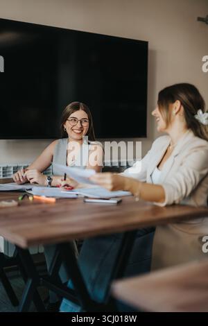Zwei Frauen, die ein freundliches Gespräch am Arbeitsplatz führen Stockfoto