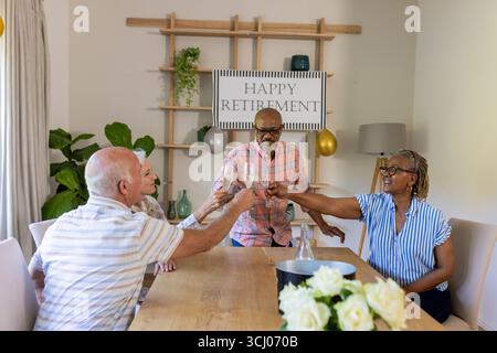 Seniorenfreunde, die auf der Ruhestandsfeier anstoßen und gemeinsam einen freudigen Meilenstein feiern Stockfoto