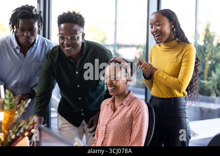 Team arbeitet an Projekten zusammen, lächelt und diskutiert Ideen im modernen Büro Stockfoto