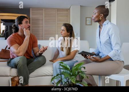 In der Schule diskutieren verschiedene Freunde Ideen, Frauen, die ein Tablet halten, engagierte Gespräche Stockfoto
