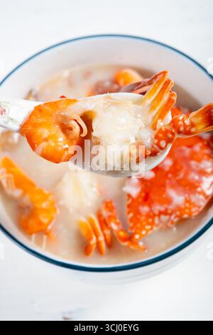 Blick auf frischen Haferbrei mit Meeresfrüchten und Garnelen in vertikaler Zusammensetzung Stockfoto