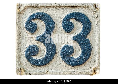 Alte verwitterte Gusseisenplatte im Retro-Stil mit der Nummer 33 isoliert auf weißem Hintergrund Stockfoto