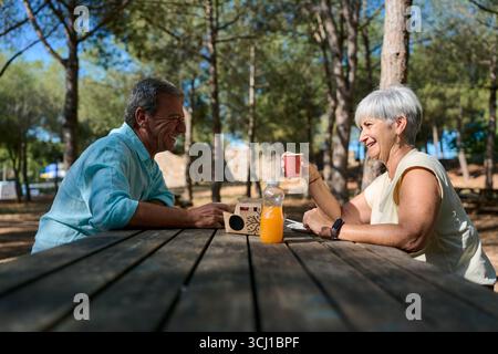 Glückliches Seniorenpaar, das ein Picknick im Park genießt Stockfoto