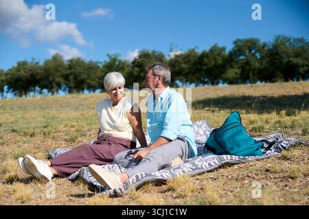 Seniorenpaar genießt entspannendes, sonniges Picknick in der Natur Stockfoto