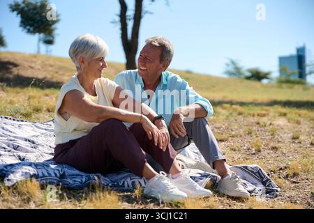 Glückliches Seniorenpaar, das einen sonnigen Tag im Park genießt Stockfoto