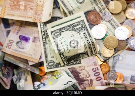 Geld aus verschiedenen Ländern der Welt ist in einem Stapel von Münzen und Banknoten verstreut. US-Dollar, rumänischer lei und Euro. Stockfoto