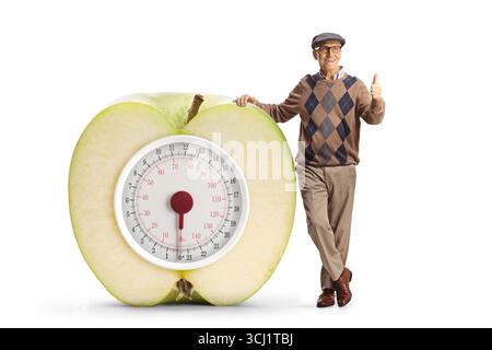 Älterer Mann und grüner Apfel mit analoger Waage, isoliert auf weißem Hintergrund Stockfoto