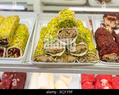 Grüne Pistazien türkischer Genuss gefüllt mit Sahne und Nüssen in einem Süßwarengeschäft. Süße, Tradition und Gourmet-Genuss Stockfoto