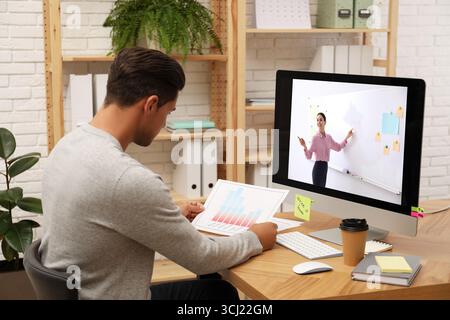 E-Learning-Konzept. Schüler, der Online-Videochat mit dem Lehrer über einen Computer am Schreibtisch führt Stockfoto